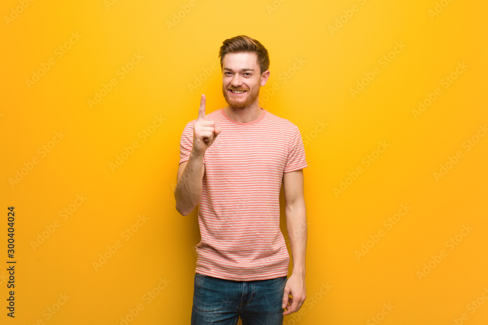 Fotografie Young redhead man showing number one