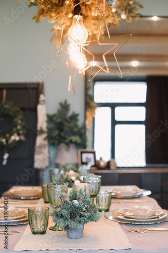 Festive table setting for Christmas dinner at home. New year and Christmas decorations. Winter holiday theme. Happy New Year 2020