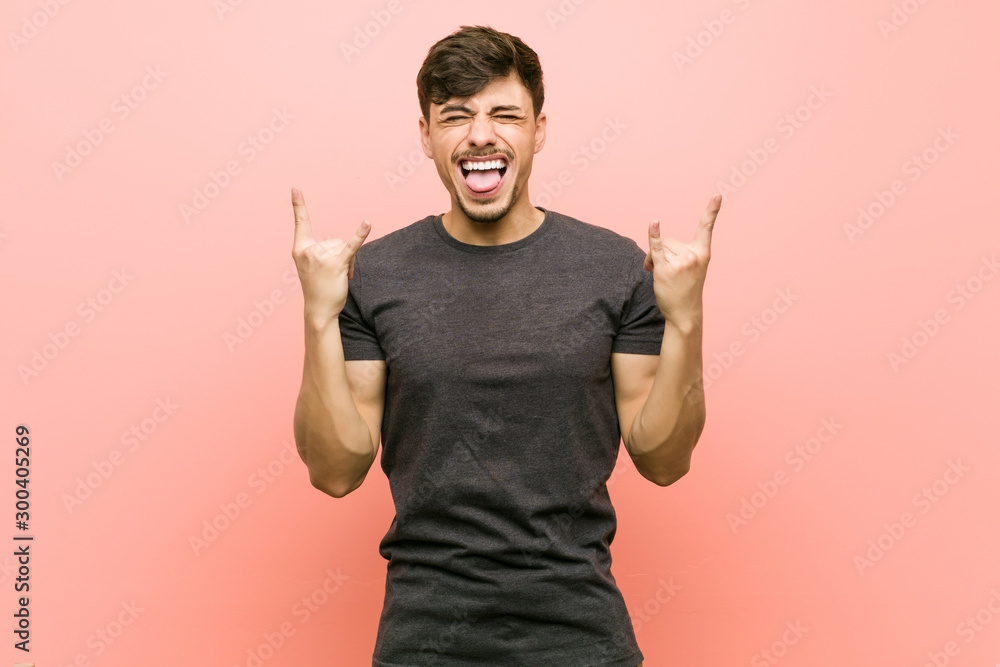 Young hispanic casual man showing rock gesture with fingers - obrazy, fototapety, plakaty 