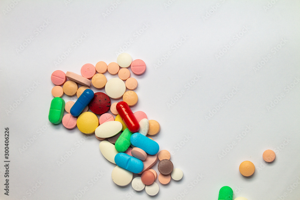Colored pills on white background. Concept of medication abuse. legal use of the pharmaceutical industry. Colored pills on white background. Concept of medication abuse. legal use of the pharmaceutical industry.