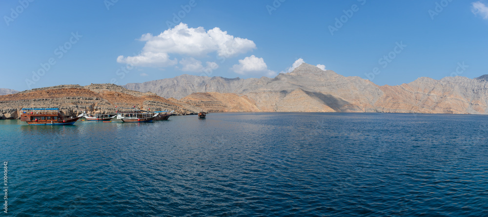Panorama View from Dhow Boat to spectacular rocky mountains of northern Oman in Musandam in the fjords.