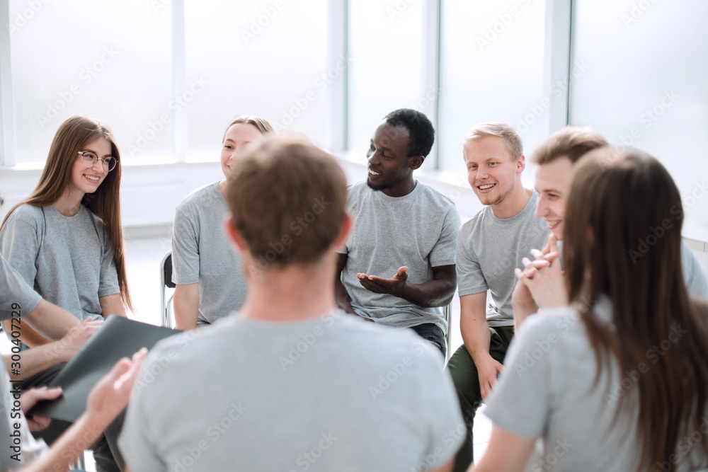 young people are discussing something sitting in a circle.