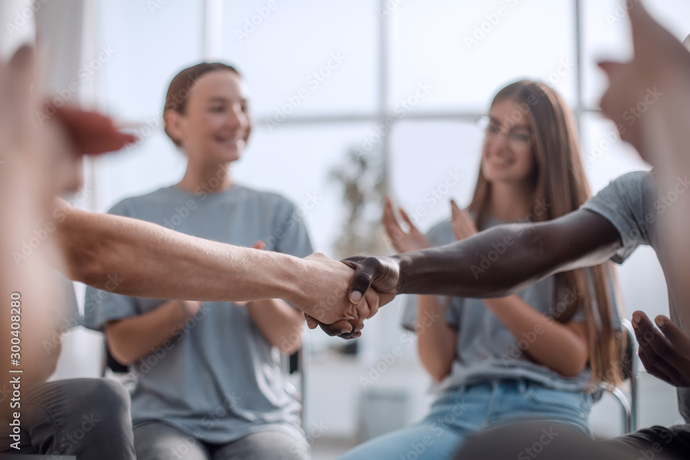 Obraz premium close up. smiling guy shaking hands with his friend