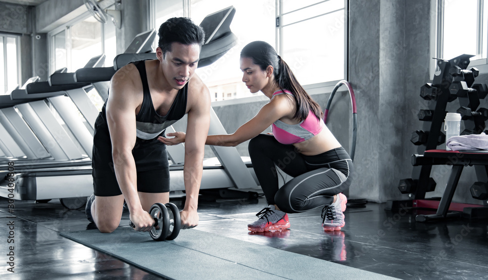 Handsome asian workout by ab wheel on yoga mat. Handsome asian workout by ab wheel on yoga mat.