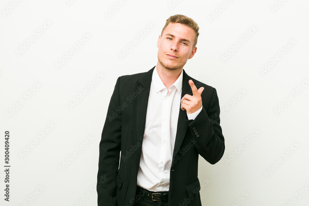 Young caucasian business man pointing with finger at you as if inviting come closer. Young caucasian business man pointing with finger at you as if inviting come closer.