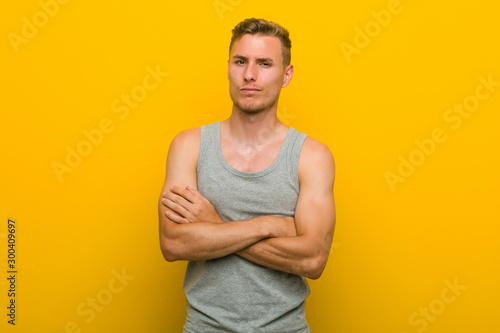 Young caucasian sport man unhappy looking in camera with sarcastic expression.