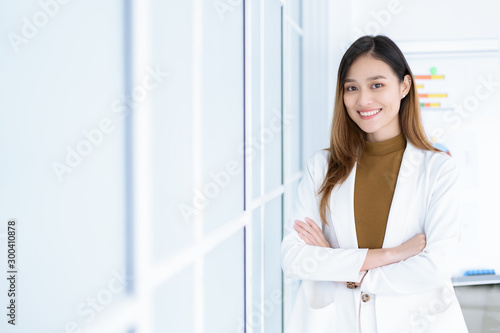 Attractive young Asian smiling woman in smart casual in office © Guitafotostudio