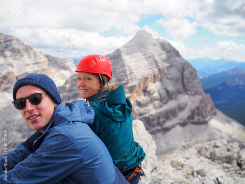 portrait of mountain climber couple in their twenties enjoying a break on the top of a mountain © makasana photo