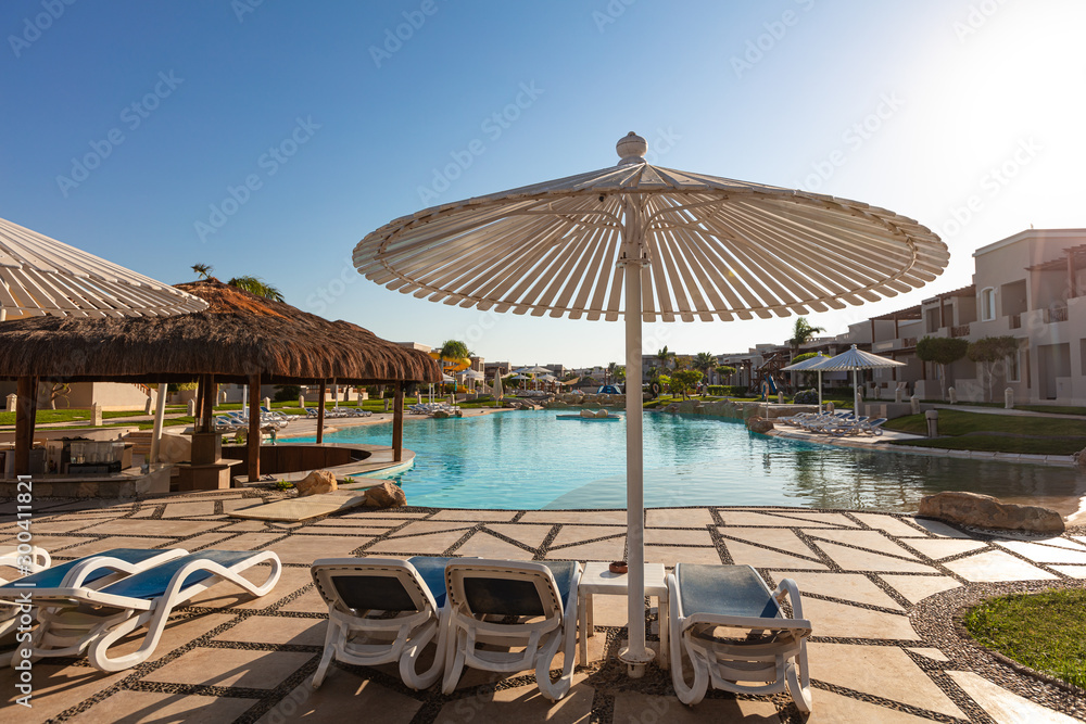 sunshade umbrellas and sunbeds near pool