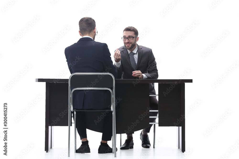 two businessmen talking, sitting at his Desk two businessmen talking, sitting at his Desk