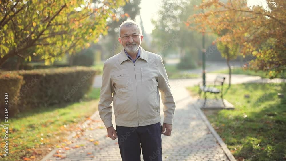 Elderly man in jacket. Old bearded man walking in autumn park Elderly man in jacket. Old bearded man walking in autumn park
