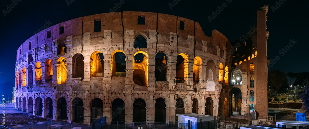 Panorama of night Coliseum or Flavian Amphitheatre after sunset with beautiful evening illumination, Rome, Italy.