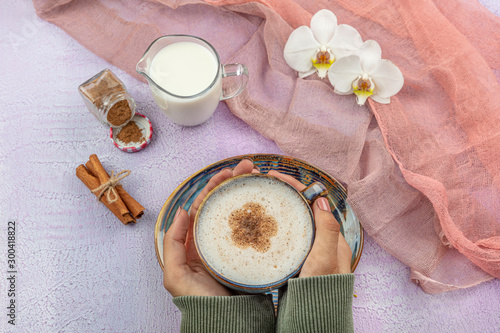 Girl's hand hold Traditional Turkish Drink Salep. Turkish salep (milky traditional hot drink). photo