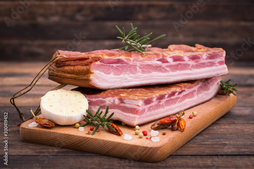 Homemade smoked bacon on wooden board photo