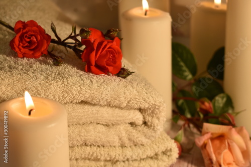 The concept of spa salon and bath. Towel, roses and candles. Relaxation and enjoyment at the spa hotel.