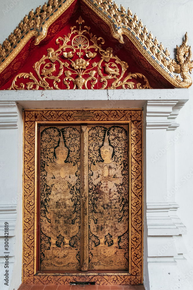 Old yellow-gold pattern with Buddha on the walls of Buddhist temple Wat Phra Singh in Chiang Mai, northern Thailand.