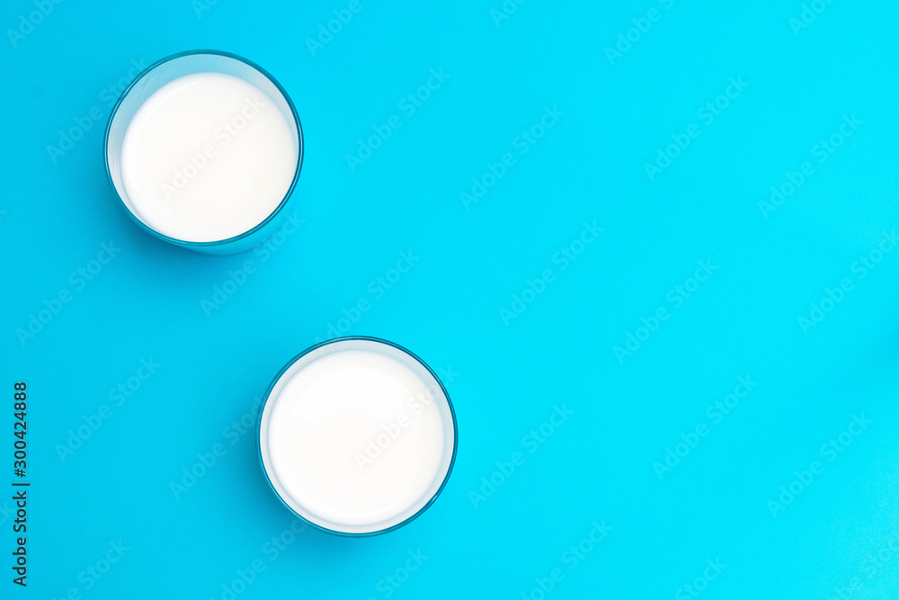 Two glasses of ayran (kefir) yogurt-based beverage with salt and water on blue background. Two glasses of ayran (kefir) yogurt-based beverage with salt and water on blue background.