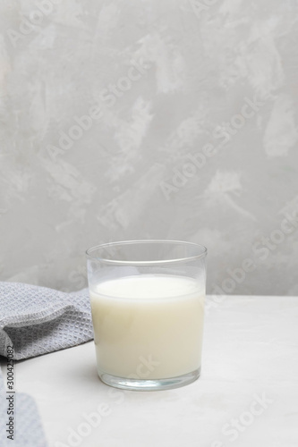 Cup of plain fermented drink ayran (kefir) on grey neutral background.