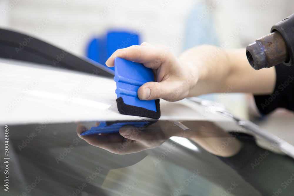 Installation of protective film for car paint.Professional installation of protective film on the car body.