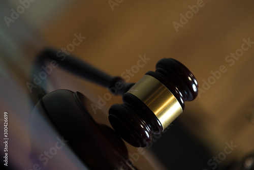 Law and Justice concept. Mallet of the judge, books, scales of justice. Gray stone background, reflections on the floor, place for typography. Courtroom theme. photo