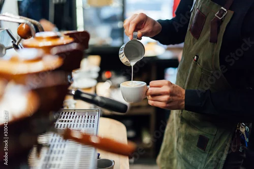 Obraz Barista making coffee in coffee shop, hands holding cup of coffee.