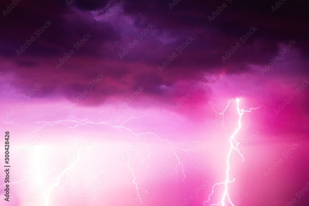 A lightning strike on the cloudy sky. Pink, lilac and purple toned image A lightning strike on the cloudy sky. Pink, lilac and purple toned image