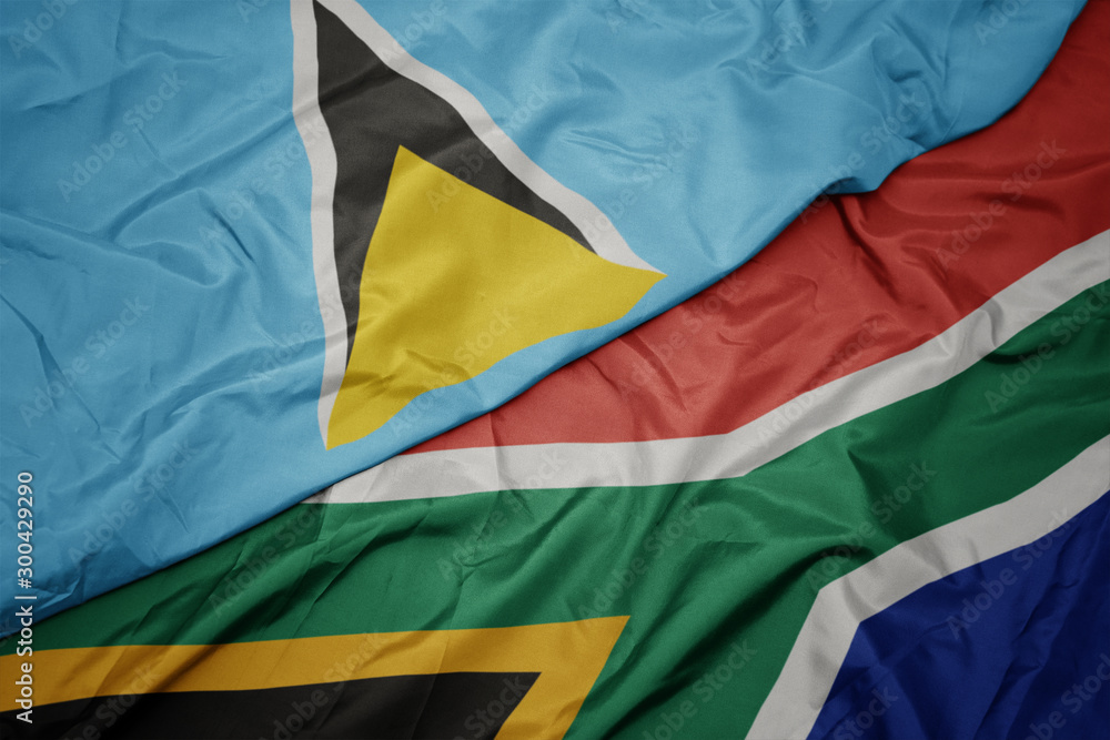 waving colorful flag of south africa and national flag of saint lucia.