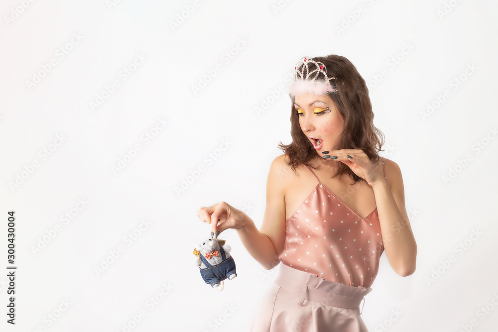 A beautiful sexy girl in a fairy tale fairy costume is holding a symbol of 2020-a rat. Close-up on white background. Happy New Year! A beautiful sexy girl in a fairy tale fairy costume is holding a symbol of 2020-a rat. Close-up on white background. Happy New Year!