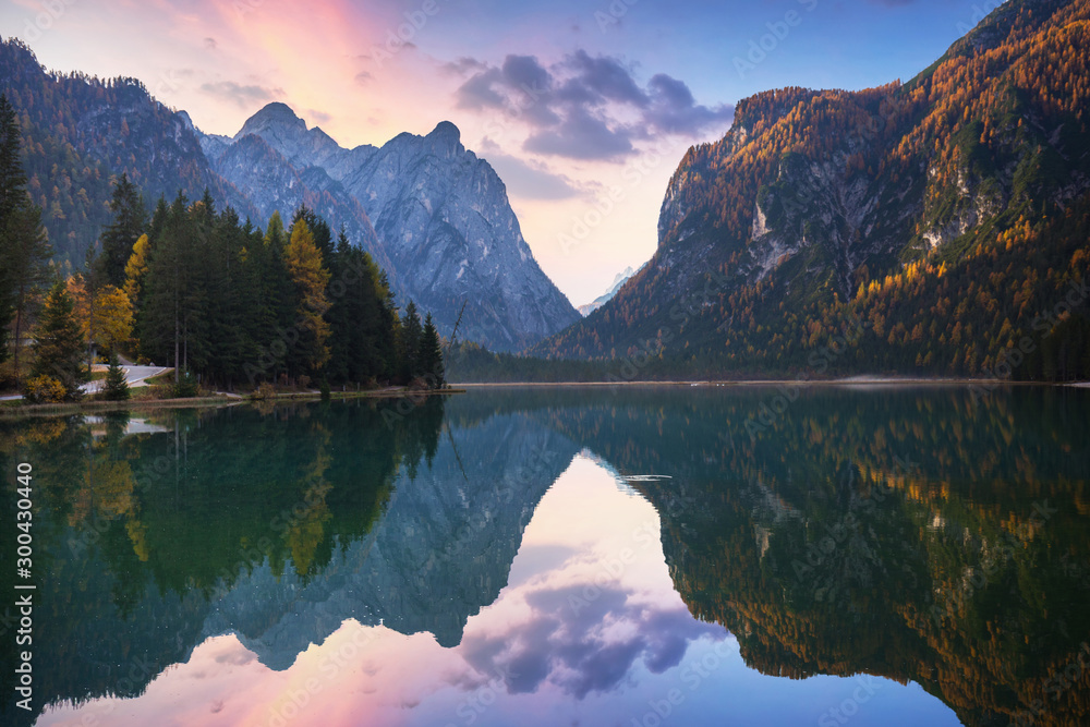 Dolomites mountains with reflection in Lago di Dobbiaca lake at autumn. Italy