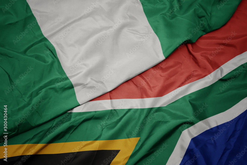 waving colorful flag of south africa and national flag of nigeria.