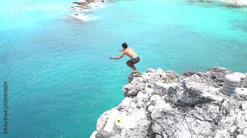 Ocean gainer cliff jump into blue lagoon, Indonesia. Shot on Sony a6500 in 120fps. photo