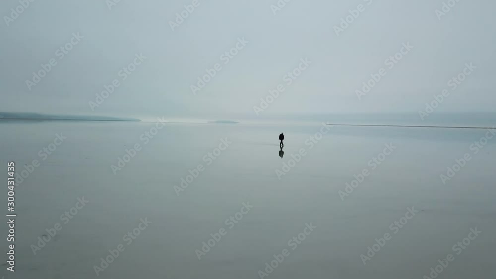 Surreal Aerial Scene of Man Walking on Plain Mirror Field With Horizon Reflection. Bonneville Salt Flats, Utah USA Surreal Aerial Scene of Man Walking on Plain Mirror Field With Horizon Reflection. Bonneville Salt Flats, Utah USA