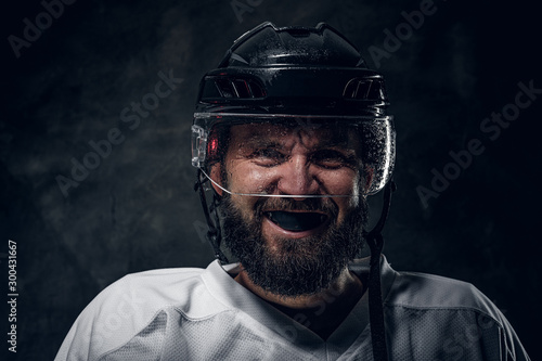 Obraz na płótnie Toothless bearded hockey player in protective helmet is looking to the camera and screaming