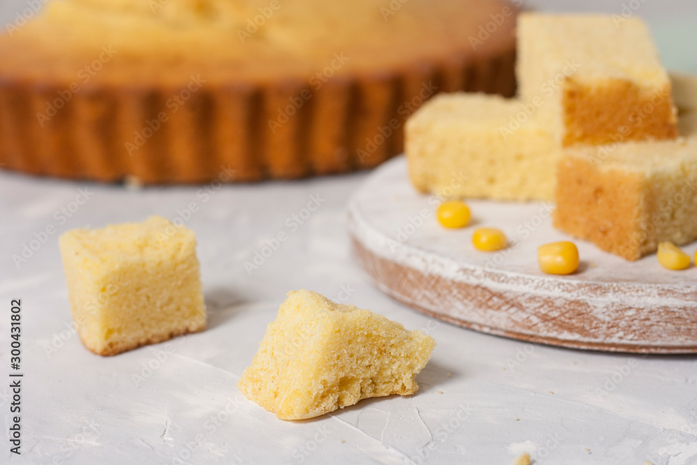 Slices of freshly baked corn bread on a white table.