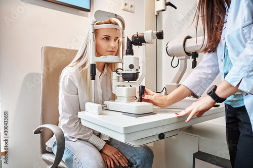 Tableau sur toile Two attractive females in oculist cabinet, one of them is a doctor, the second one is a patient