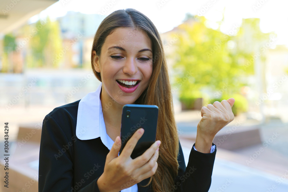 Happy successful business woman reading good news on smartphone and celebrate outdoor. Happy successful business woman reading good news on smartphone and celebrate outdoor.