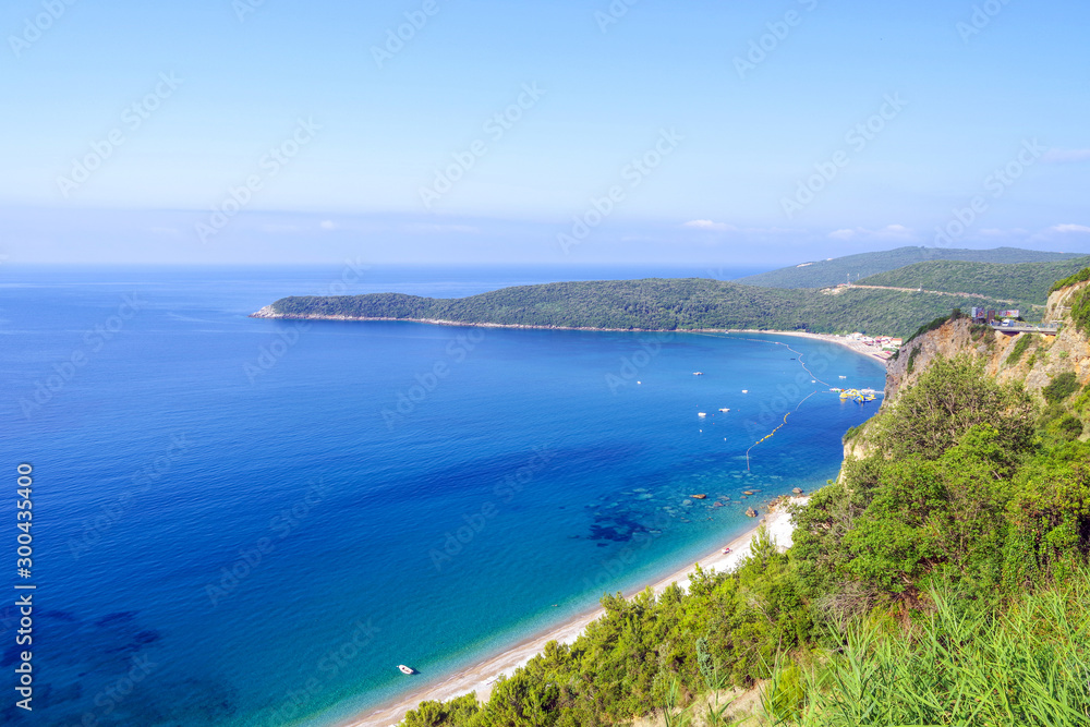 Panoramic view from above to the Adriatic sea coastline and Jaz beach near a Budva city, Montenegro. The concept of summer holidays and travel.