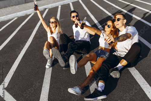 A group of friends have fun and celebrate the victory sitting in the city on the road