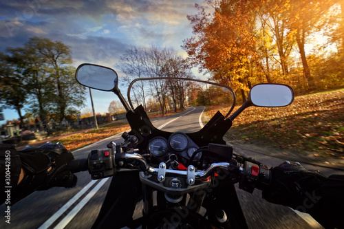 Fototapeta Driving a motorbike on an autumn sunny day