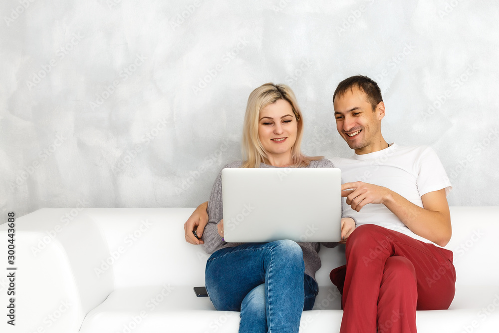 Portrait of happy young couple using laptop isolated on gray background Portrait of happy young couple using laptop isolated on gray background