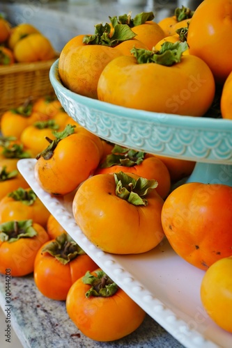 Fototapeta Naklejka Na Ścianę i Meble -  Basket of freshly picked  orange persimmon kaki fruits