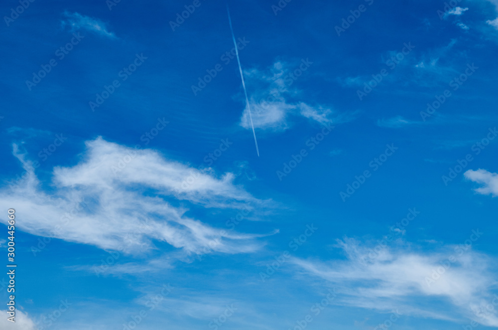 Trace of an airplane in the sky. Bright sky with white clouds. Trace of an airplane in the sky. Bright sky with white clouds.