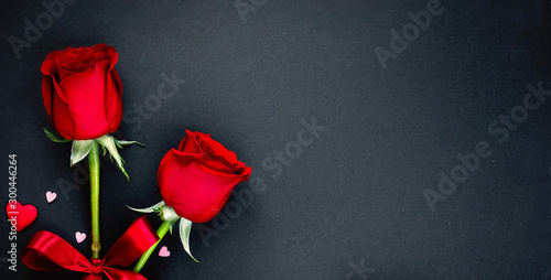 Fototapeta Naklejka Na Ścianę i Meble -  Beautiful valentines day background with red roses and hearts on black background. Flat lay, Copy space