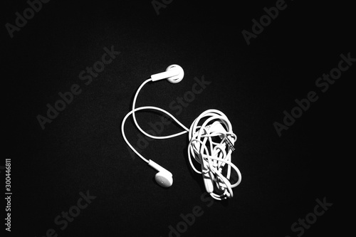 Entangled White Telephone Earphones isolated on Black Background