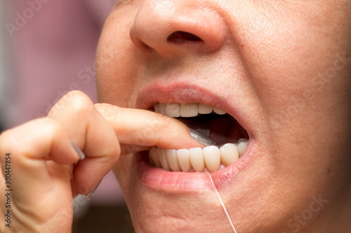 Woman Flossing her Teeth for Good Dental Hygiene