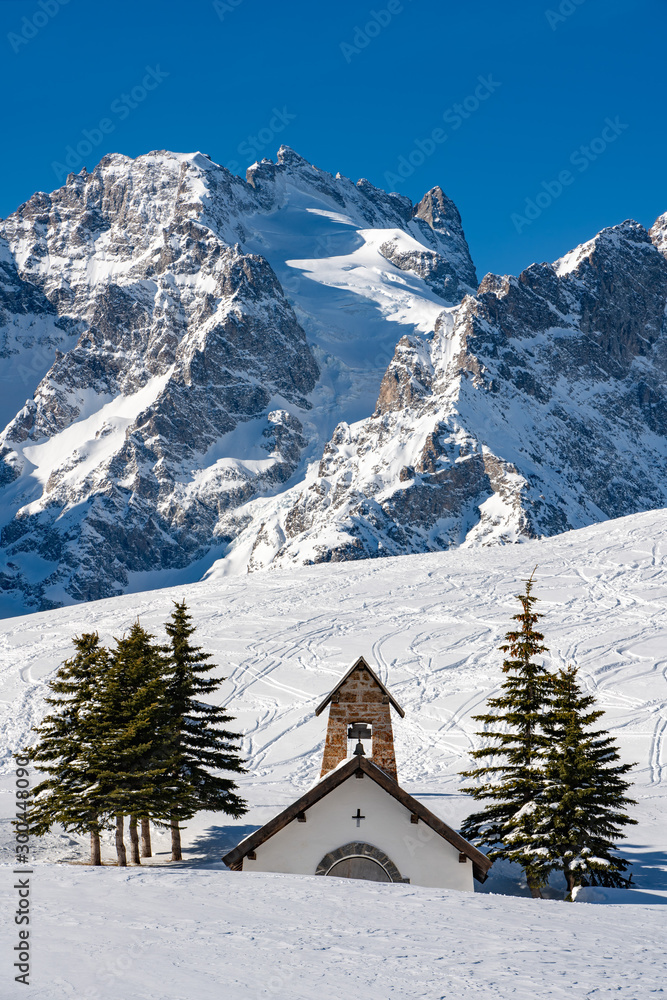 Winter view of the glaciers and mountain peaks of the Ecrins National Park (La Meije and Lautaret Glacier) with La Chappelle des Fusillés. Col du Lautaret, Hautes-Alpes, Alps, France