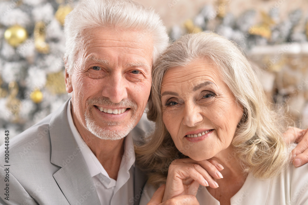 hugging senior couple with blurred Christmas decorations hugging senior couple with blurred Christmas decorations