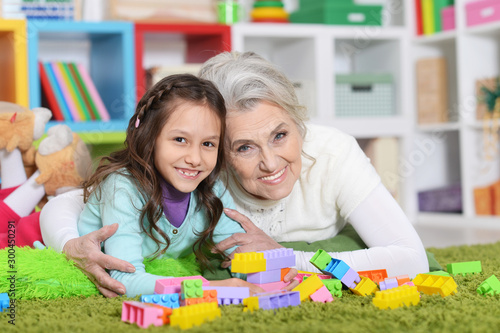 Close up portrait of cute girl and grandmother playing