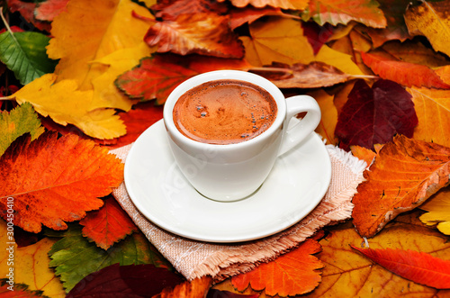 Autumn composition. Cup of coffee on colorful autumn leaves. Creative autumn thanksgiving and fall concept. Closeup