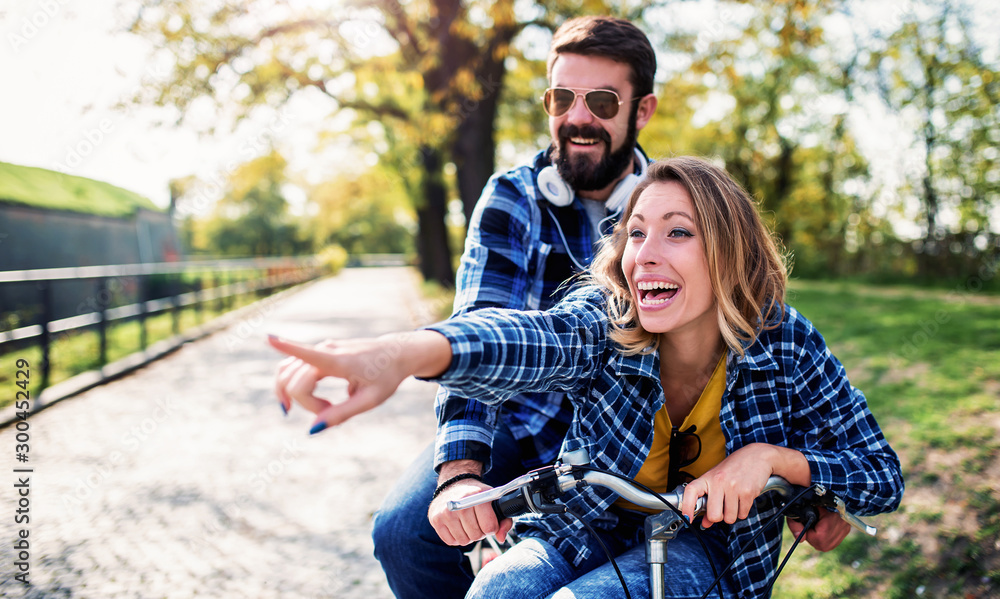 Couple in love. Romantic couple riding a bicycle in the park. Love, dating, romance Couple in love. Romantic couple riding a bicycle in the park. Love, dating, romance
